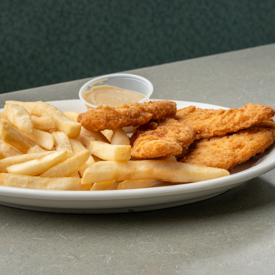 A plate of crispy chicken tenders and golden french fries with a side of dipping sauce.